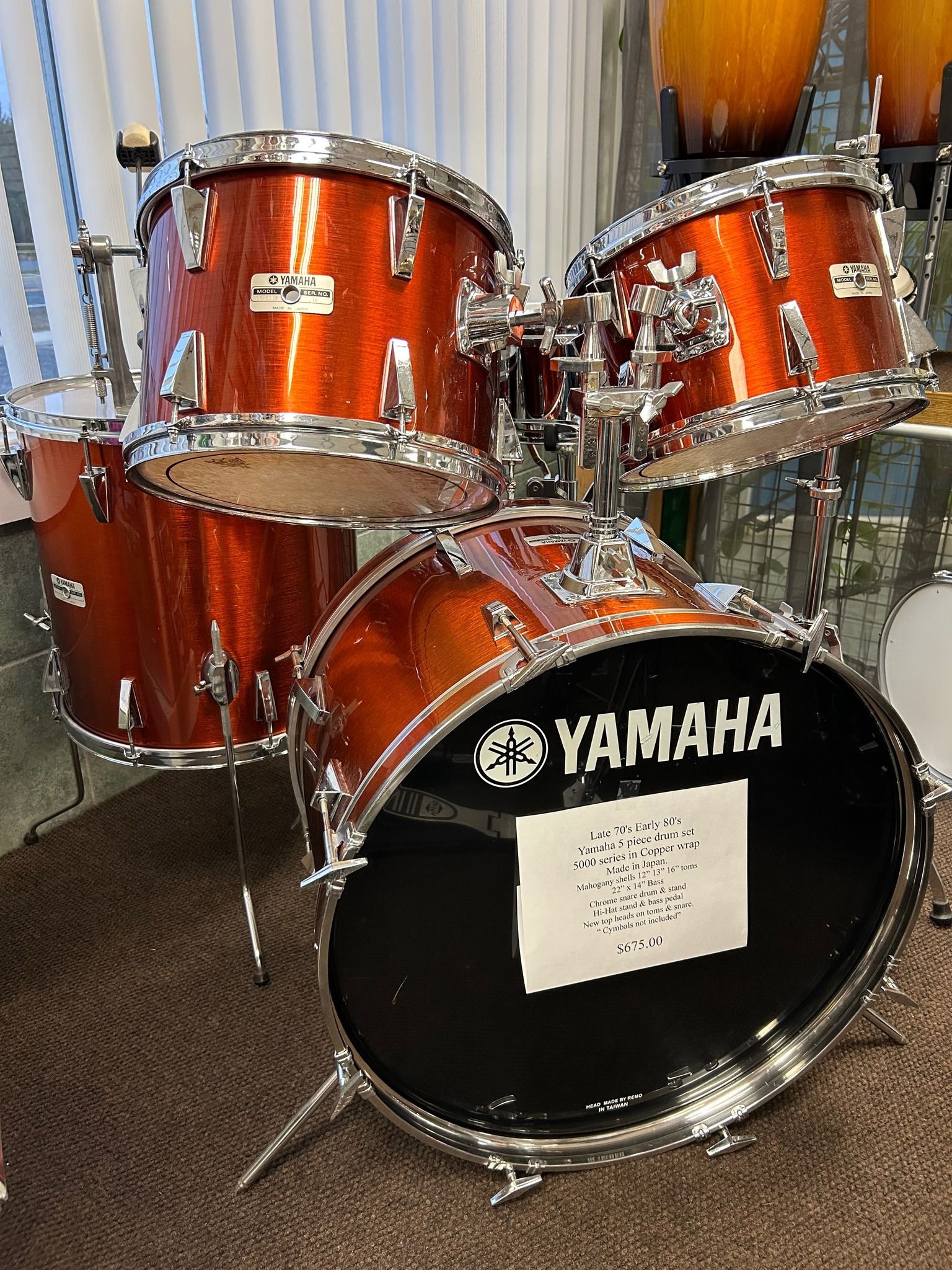 Orange glitter Yamaha drum kit on brown carpet.