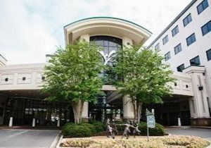 Modern building entrance with trees and a covered driveway