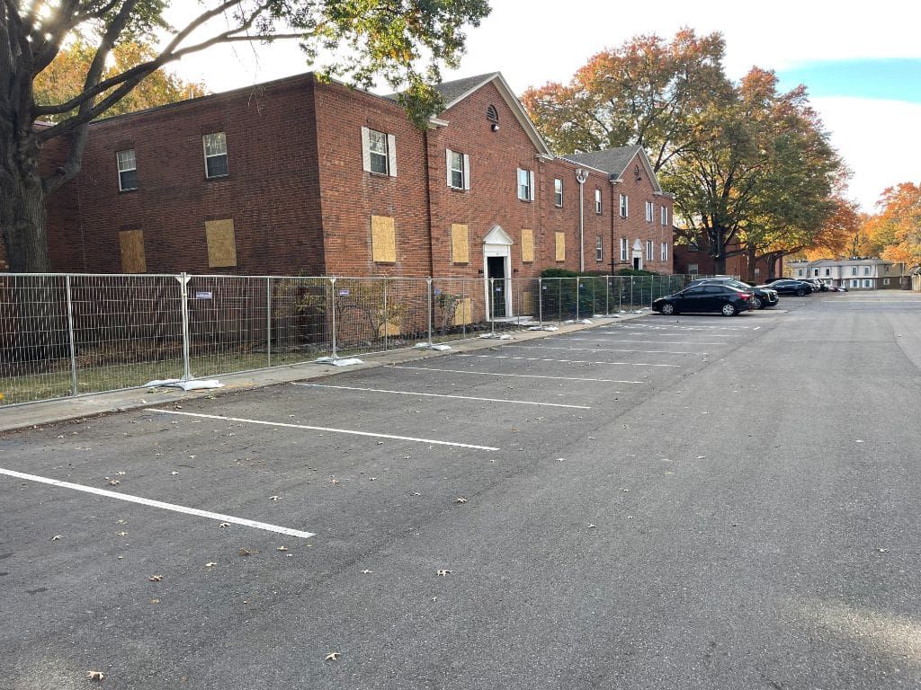 A parking lot with a brick building in the background