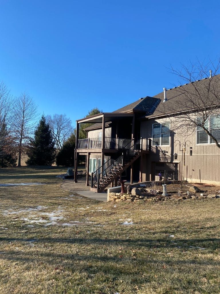 A large house with a large deck in the backyard.