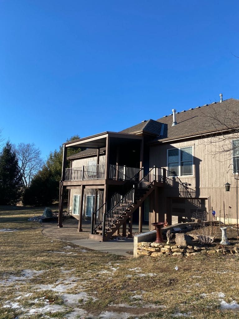 A large house with a large deck in the backyard.