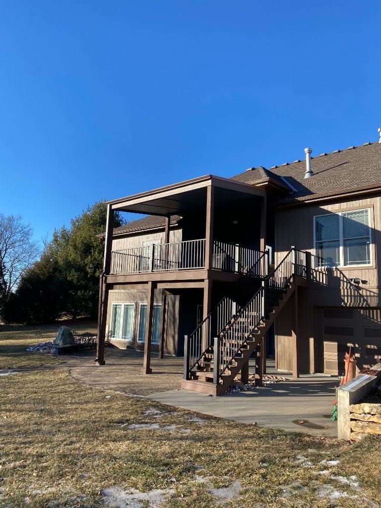 A large house with a large deck and stairs.