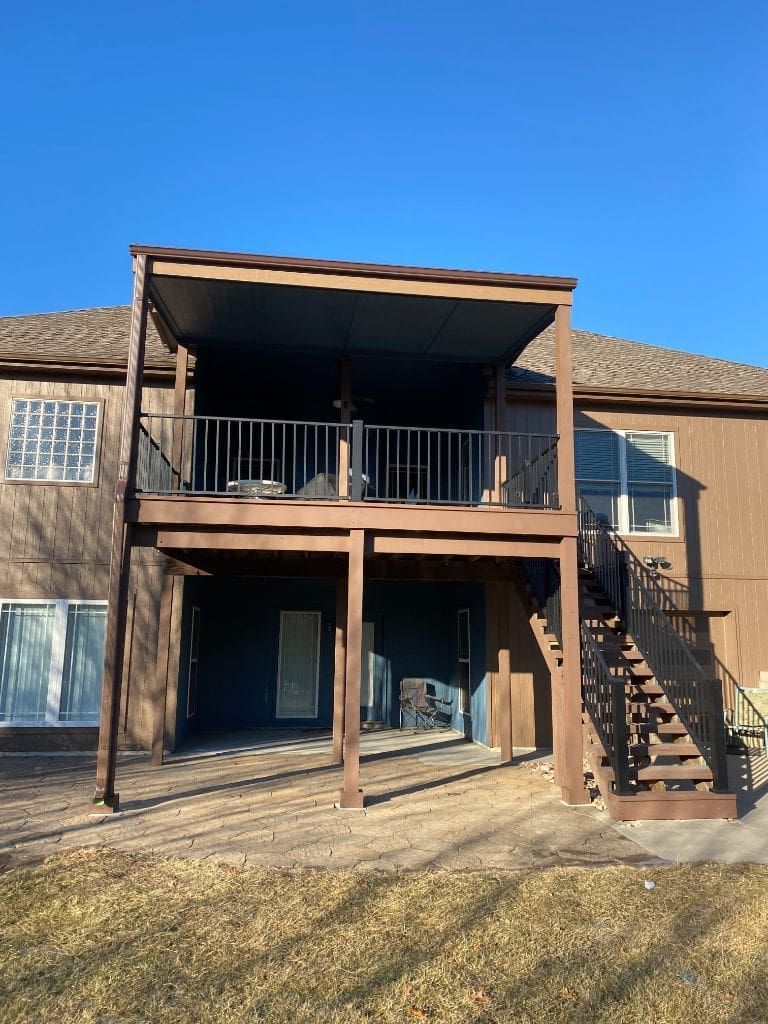 The back of a house with a large deck and stairs.
