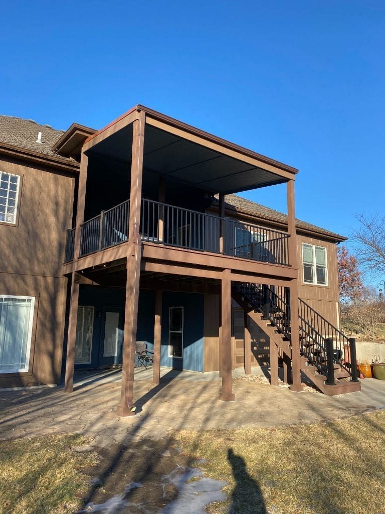 A large house with a large deck and stairs.