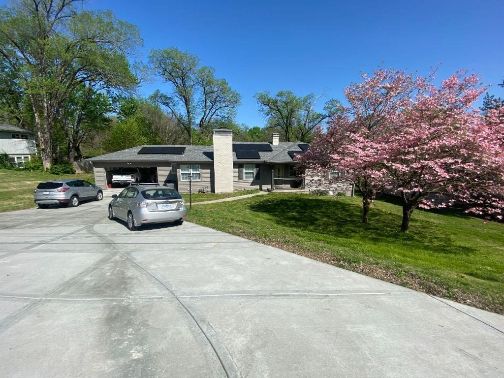 A couple of cars are parked in front of a house.