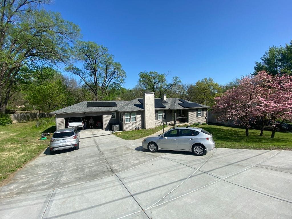 A car is parked in a driveway in front of a house.