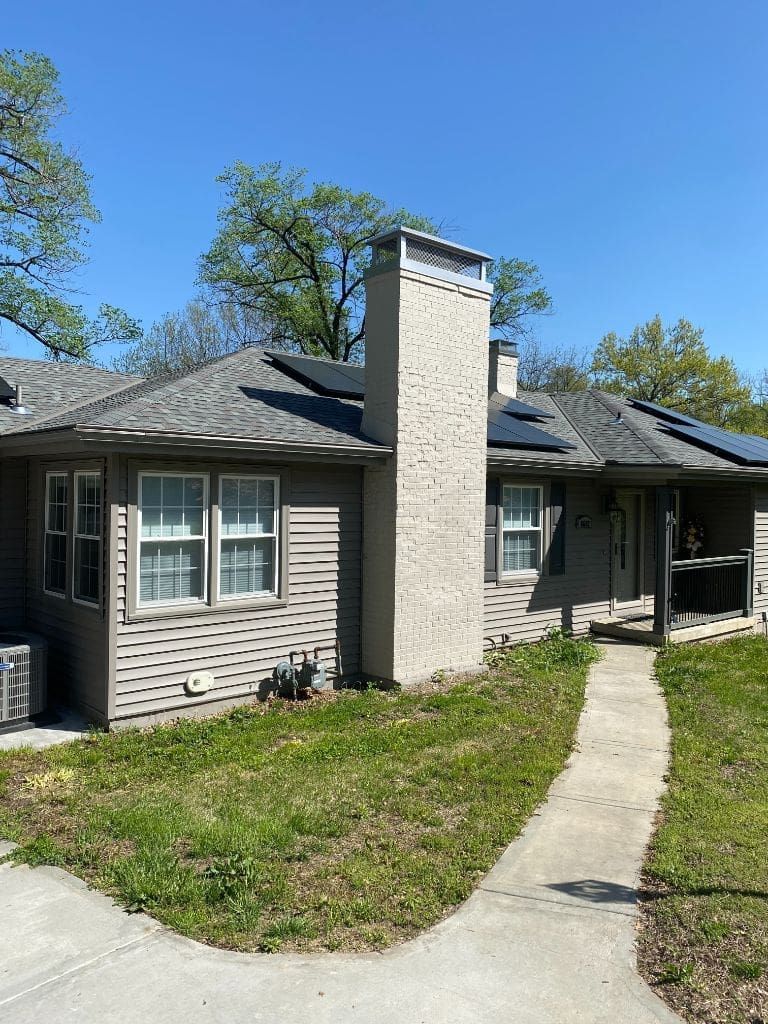 A house with a chimney and solar panels on the roof.