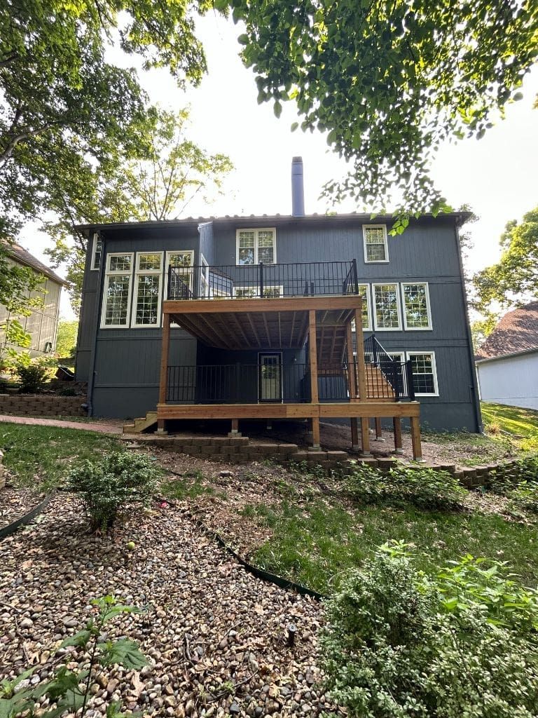 The back of a house with a large deck and stairs.