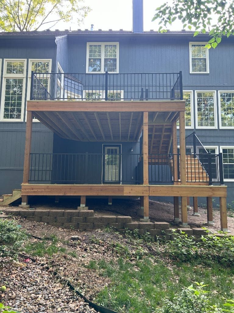 The back of a house with a wooden deck and stairs.