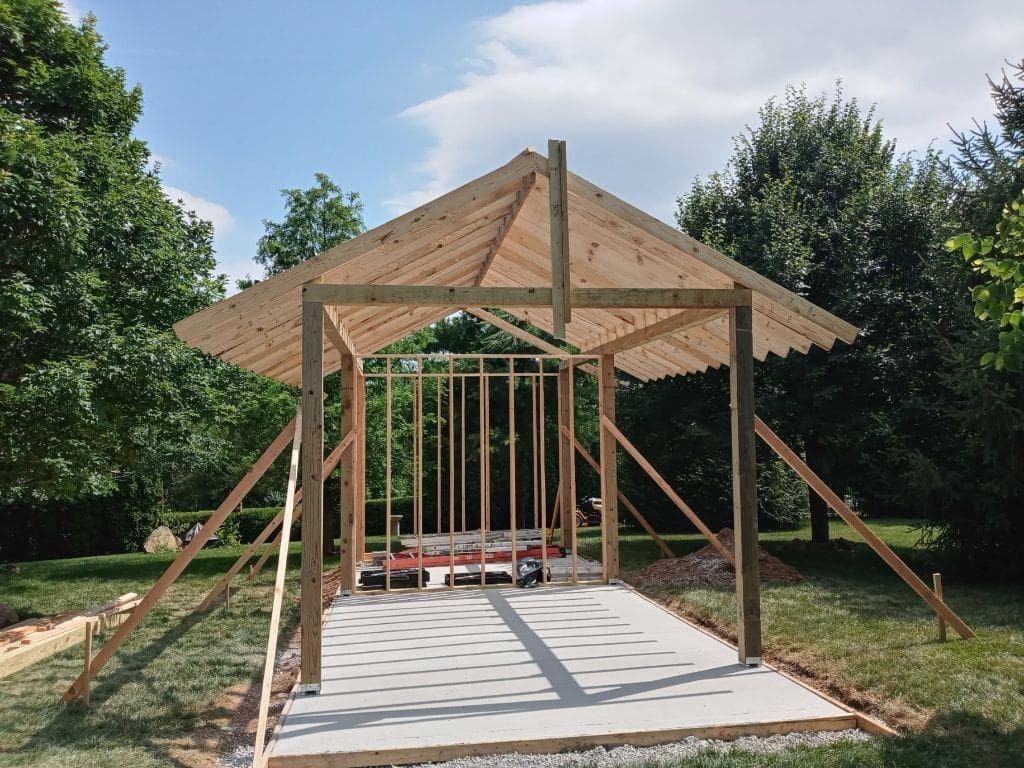 A wooden structure is being built in a backyard