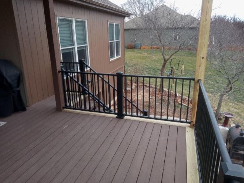 A wooden deck with a metal railing and stairs