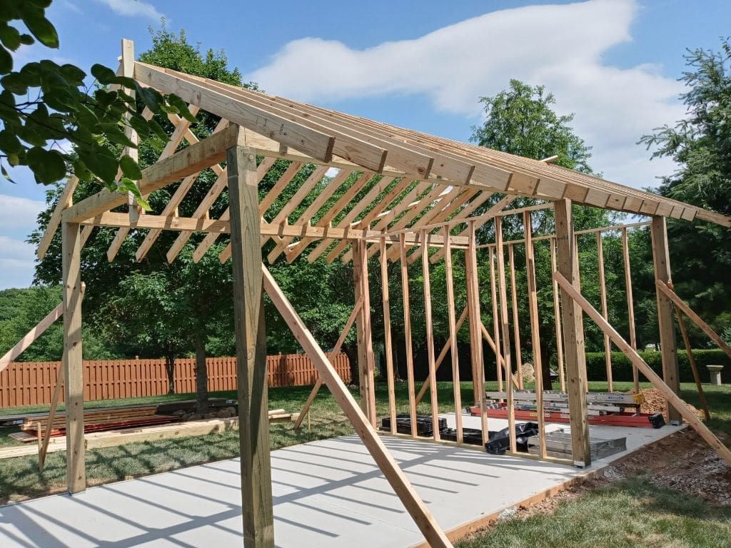 A wooden structure is being built in a backyard