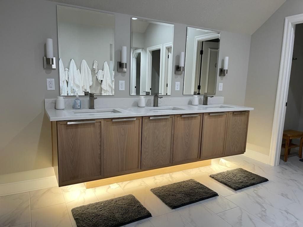 A bathroom with two sinks and three mirrors.