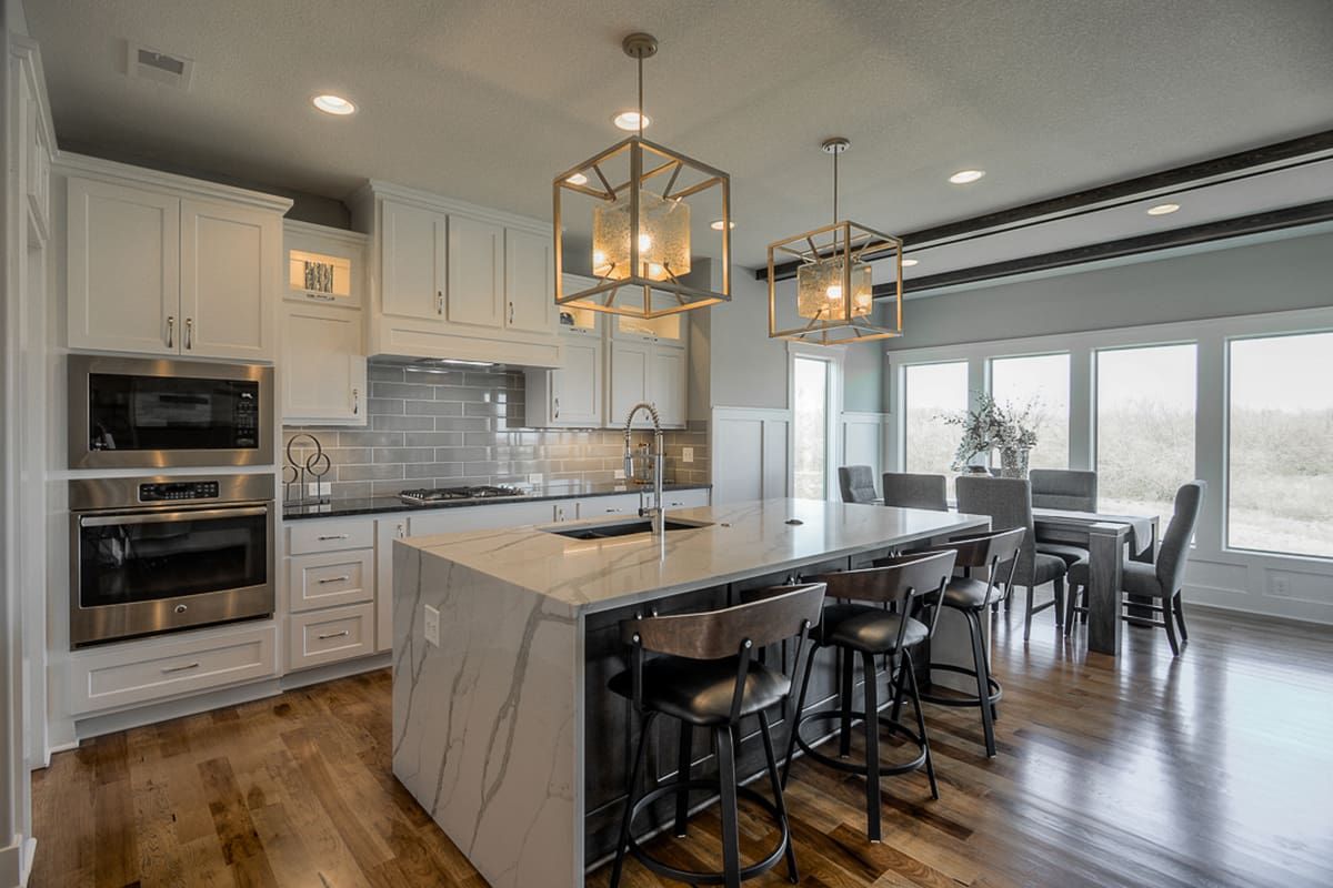 A kitchen with a large island and a dining room in the background.