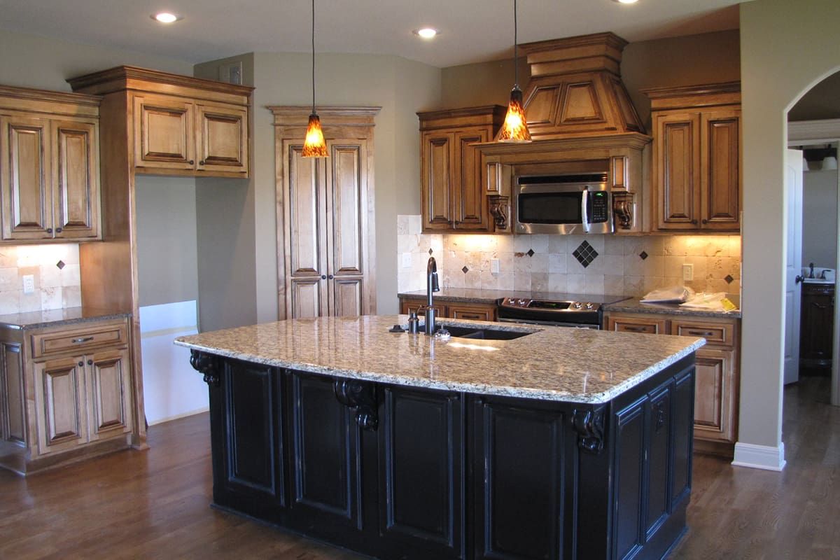 A kitchen with a large island and granite counter tops