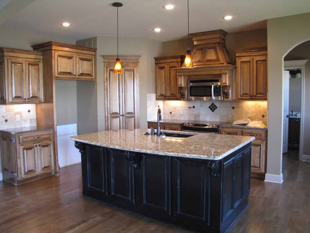 A kitchen with a large island and granite counter tops