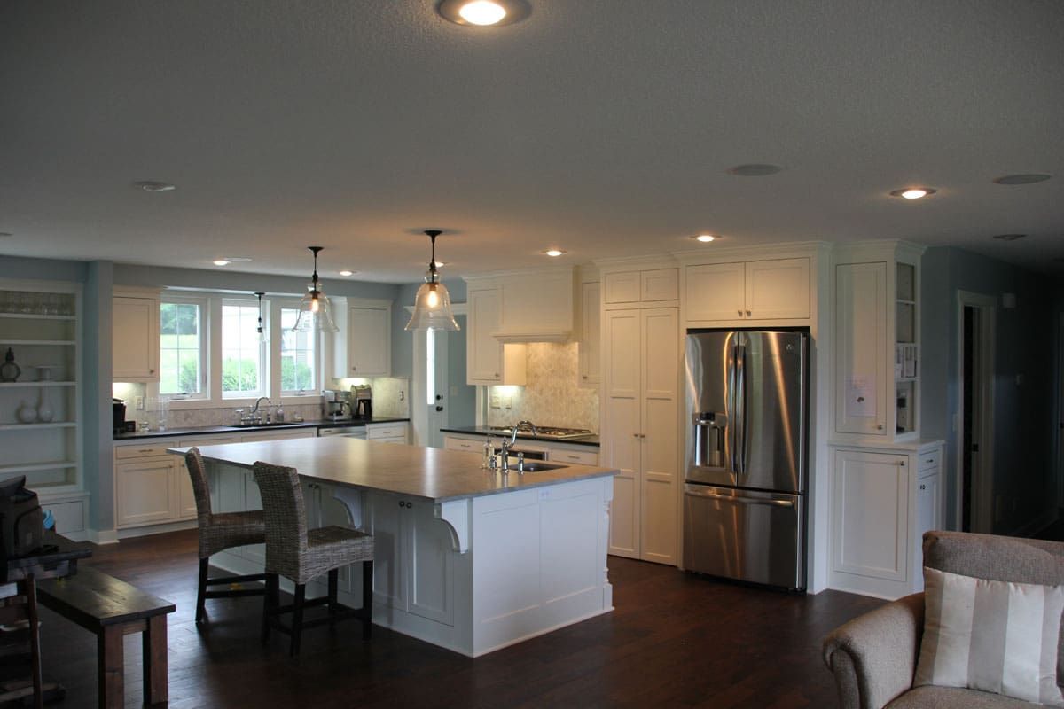 A kitchen with stainless steel appliances and a large island in the middle of the room.