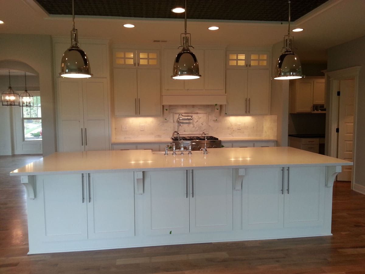 A kitchen with white cabinets and a large island