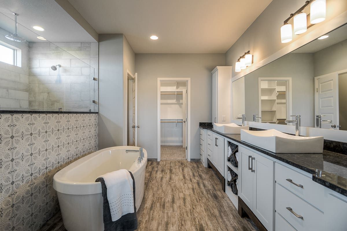 A bathroom with a bathtub , sinks , and mirrors.