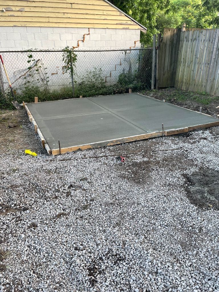 A concrete slab is being built in the backyard of a house.