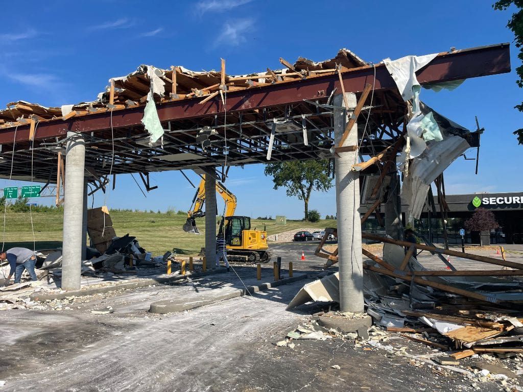 A building is being demolished by a bulldozer.