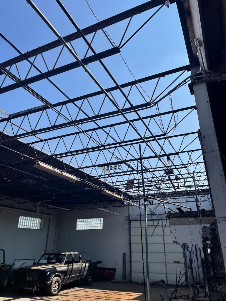 A truck is parked inside of a building with a metal roof