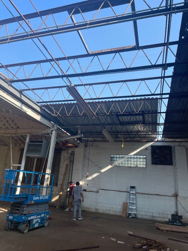 A man is standing in the middle of a building under construction.