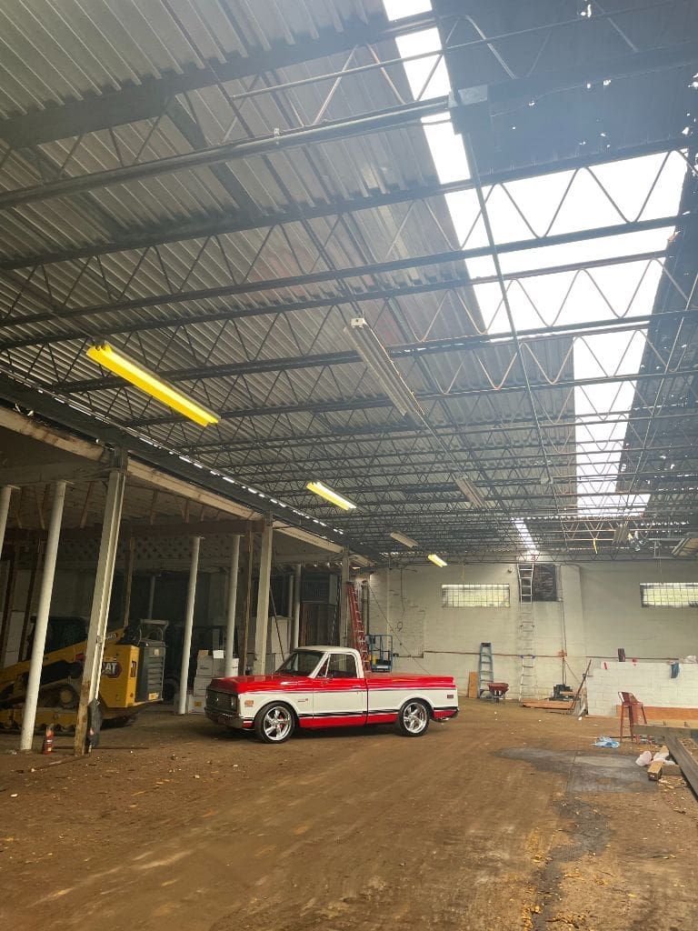 A red and white truck is parked in a large warehouse.