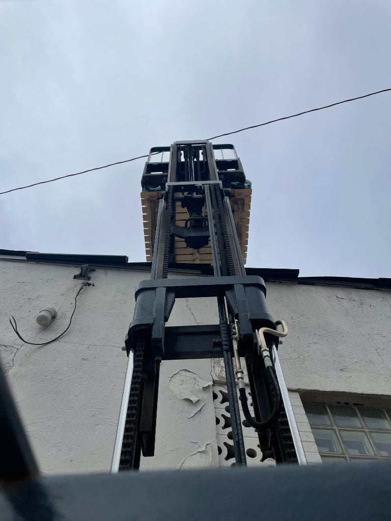 A forklift is sitting on the side of a building.