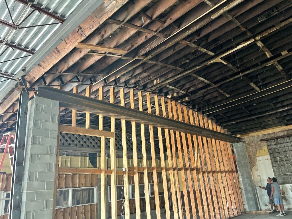 A man is standing in the middle of a building under construction.