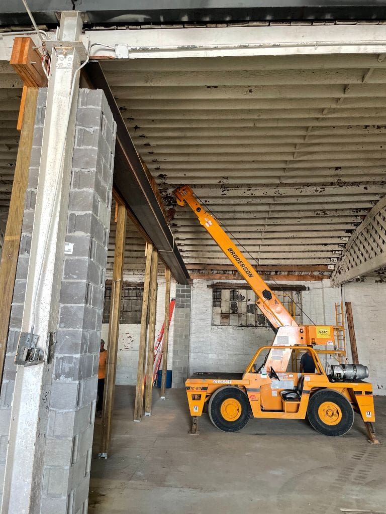 A yellow crane is sitting in a building under construction