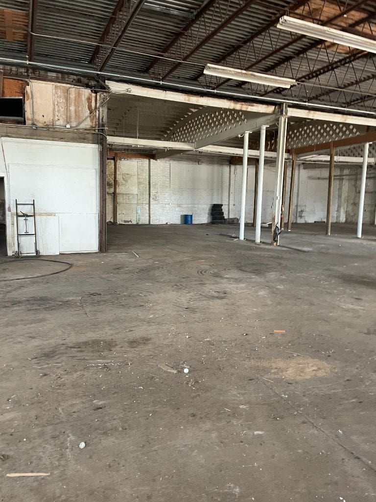A large empty warehouse with a roof and columns.