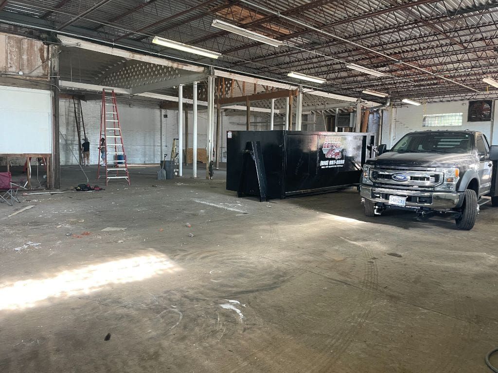 A truck is parked in a large empty warehouse.