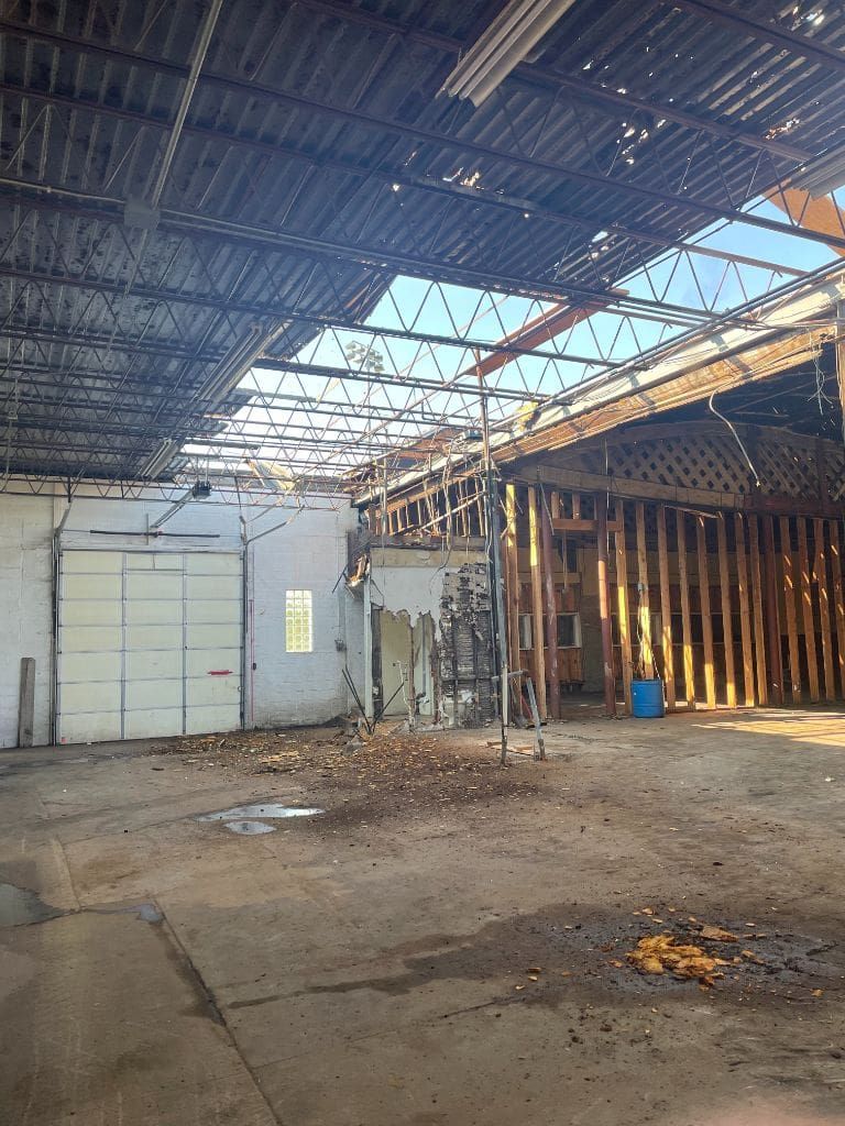A large empty warehouse with a roof that is missing.
