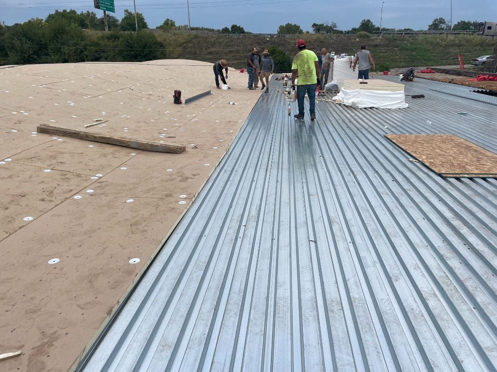 A group of people are standing on top of a metal roof.