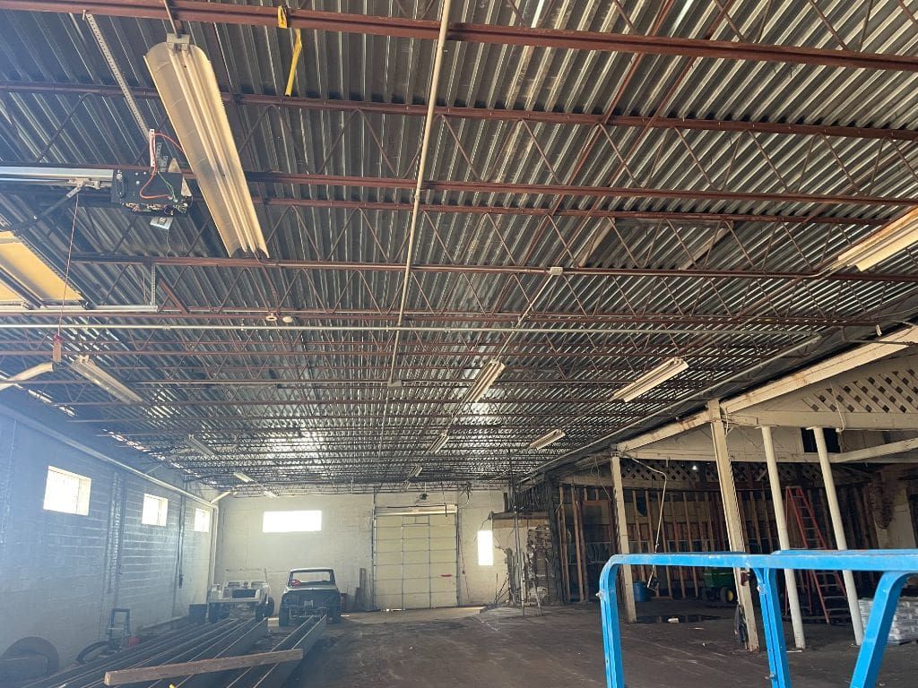 A large warehouse with a metal roof and a blue railing.