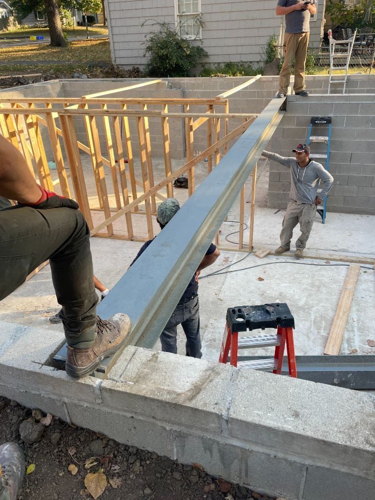 A group of construction workers are working on a house under construction.