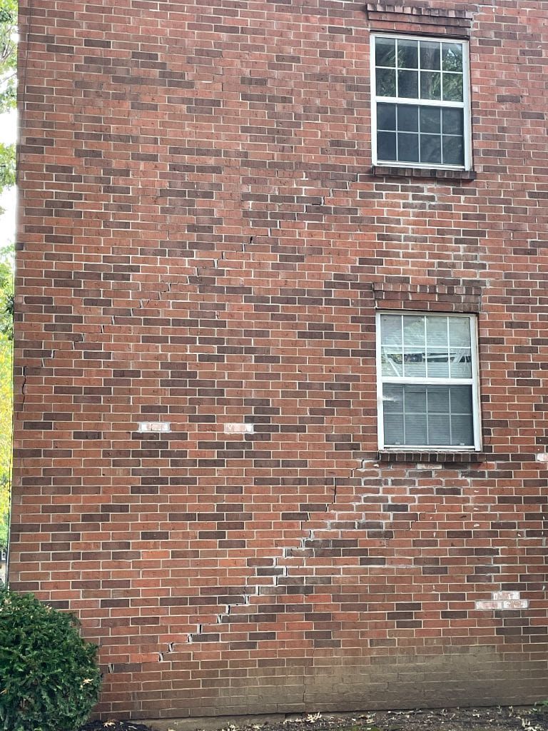 A brick building with two windows on the side