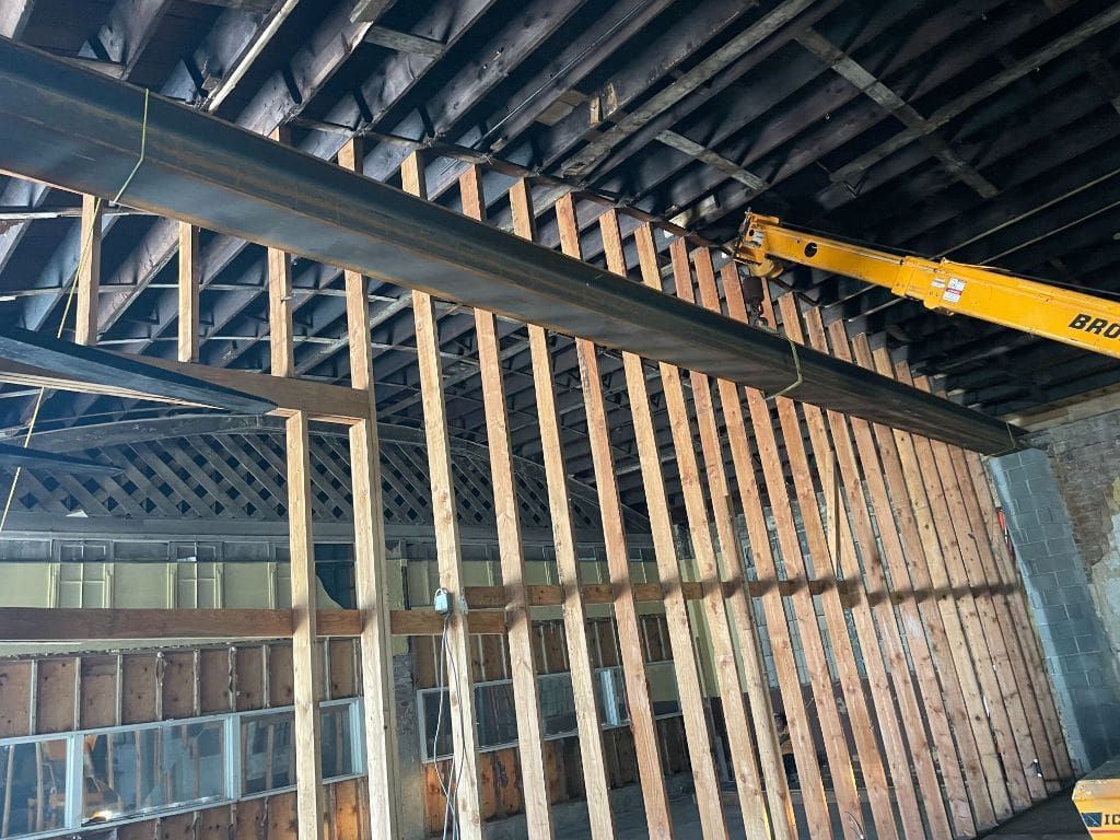 A crane is hanging from the ceiling of a building under construction.