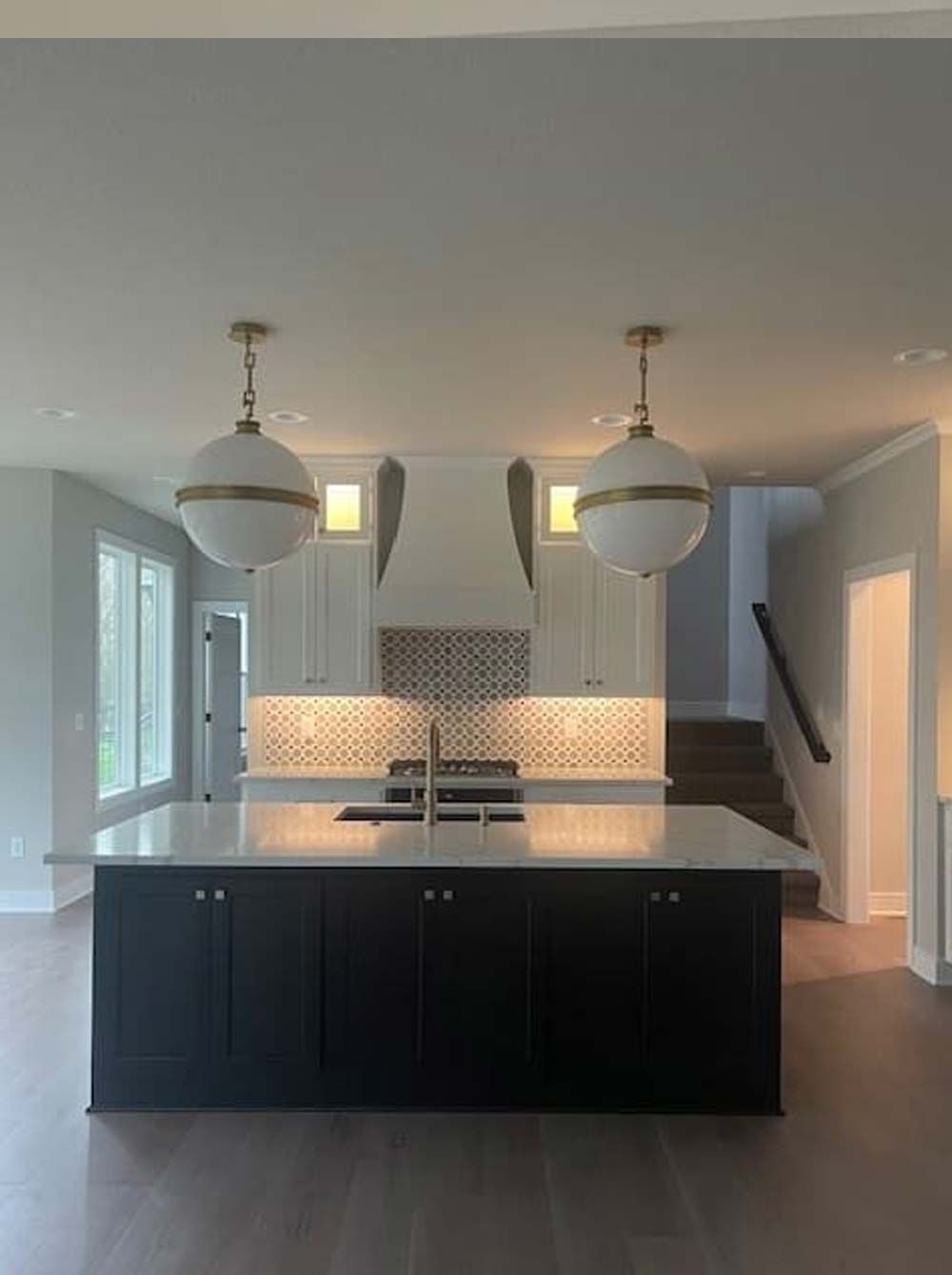 A kitchen with black cabinets and white counter tops