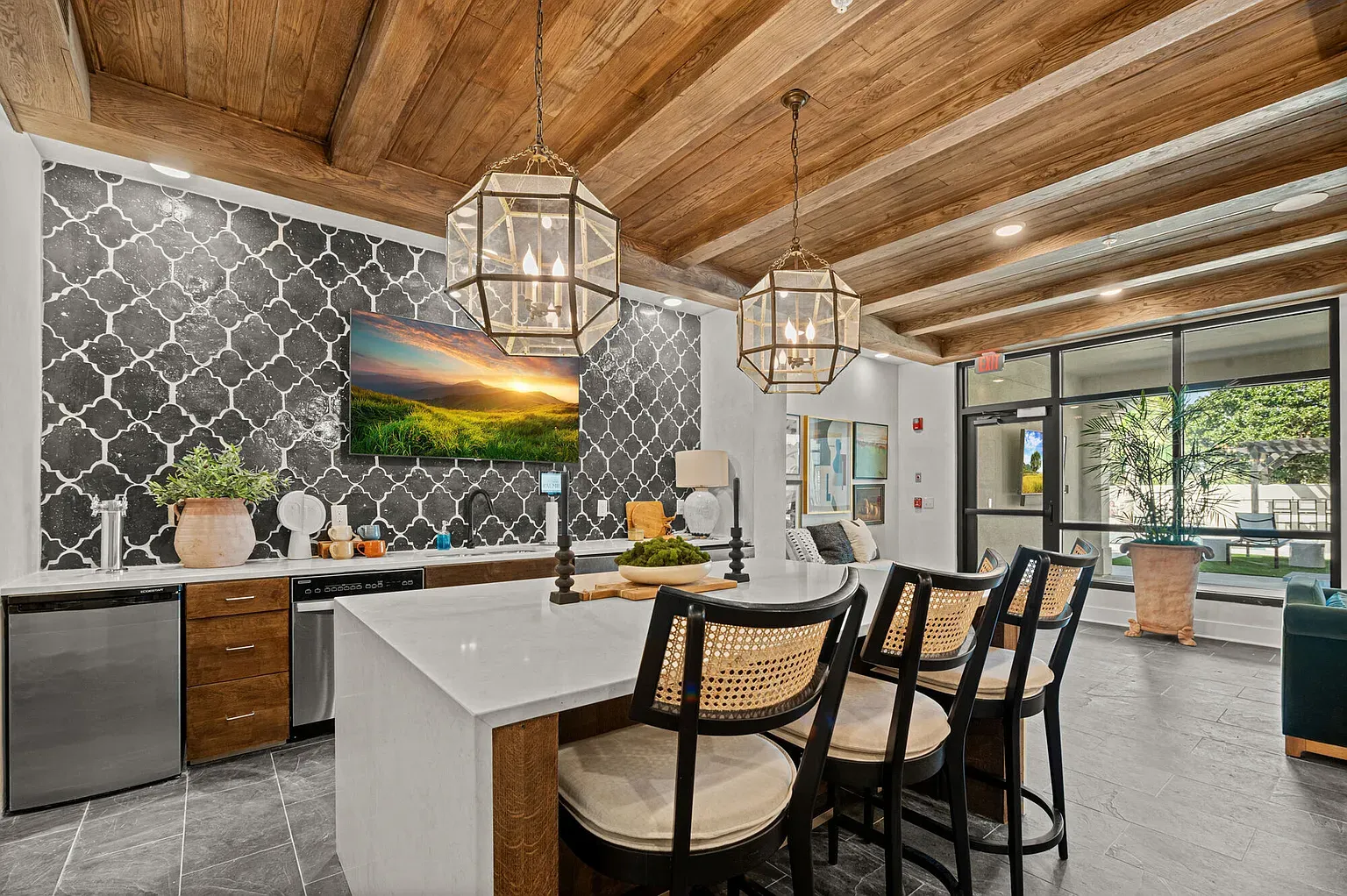 Modern kitchen with white island, dark patterned backsplash, and exposed wooden beam ceiling.