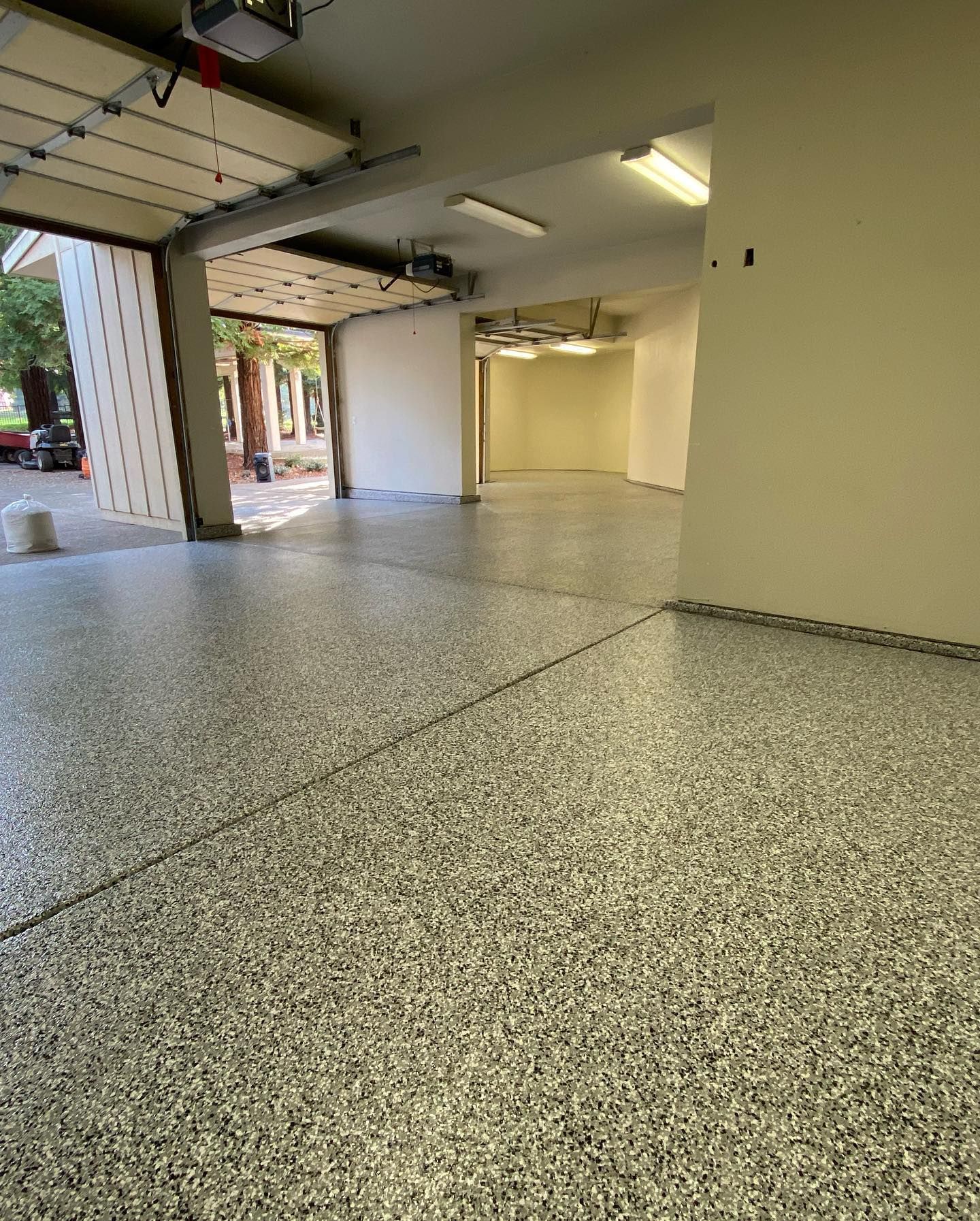 Garage floor with gray speckled epoxy coating; a blue tarp is visible.