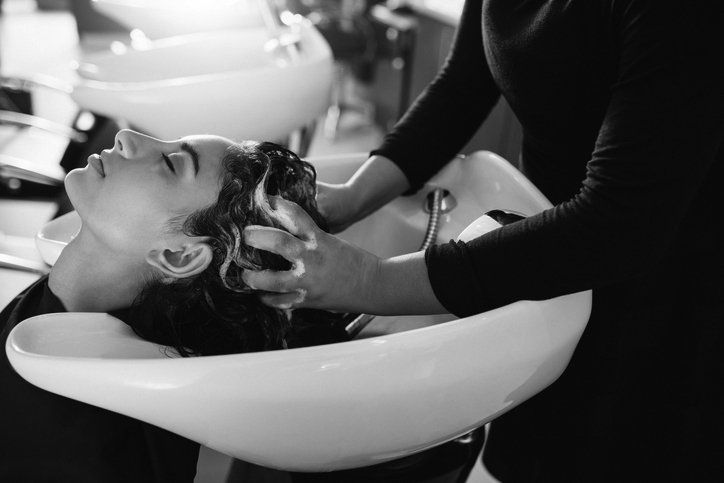 Woman getting hair shampooed at salon