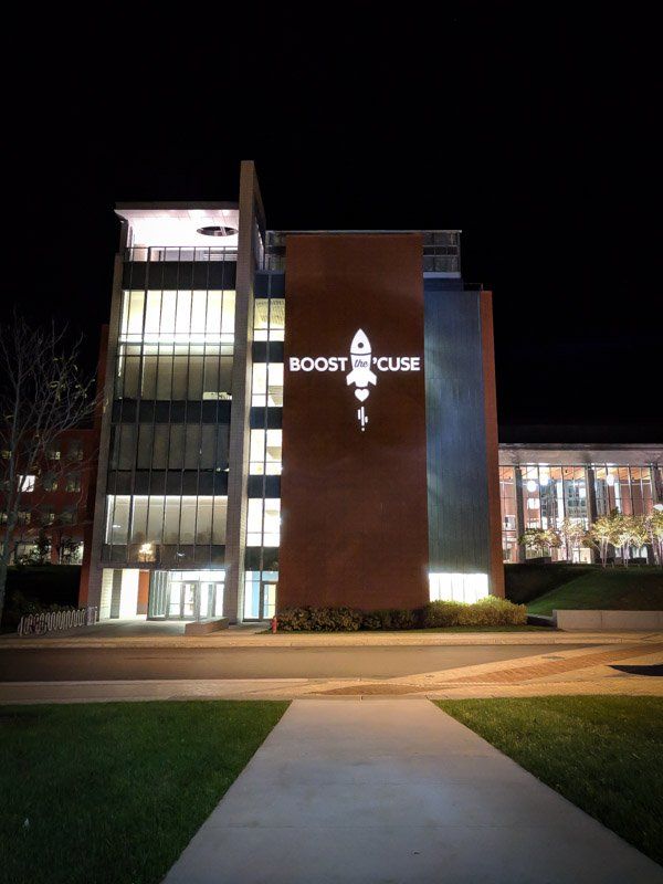 Boost House building at night, featuring a rocket logo projected on the brick facade.