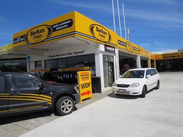 Two cars are parked in front of a store called berkes tires