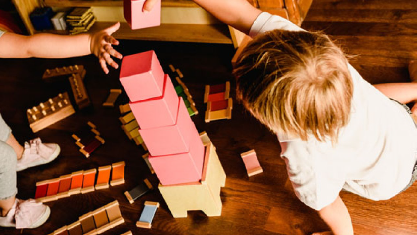 A young boy is playing with blocks on the floor.