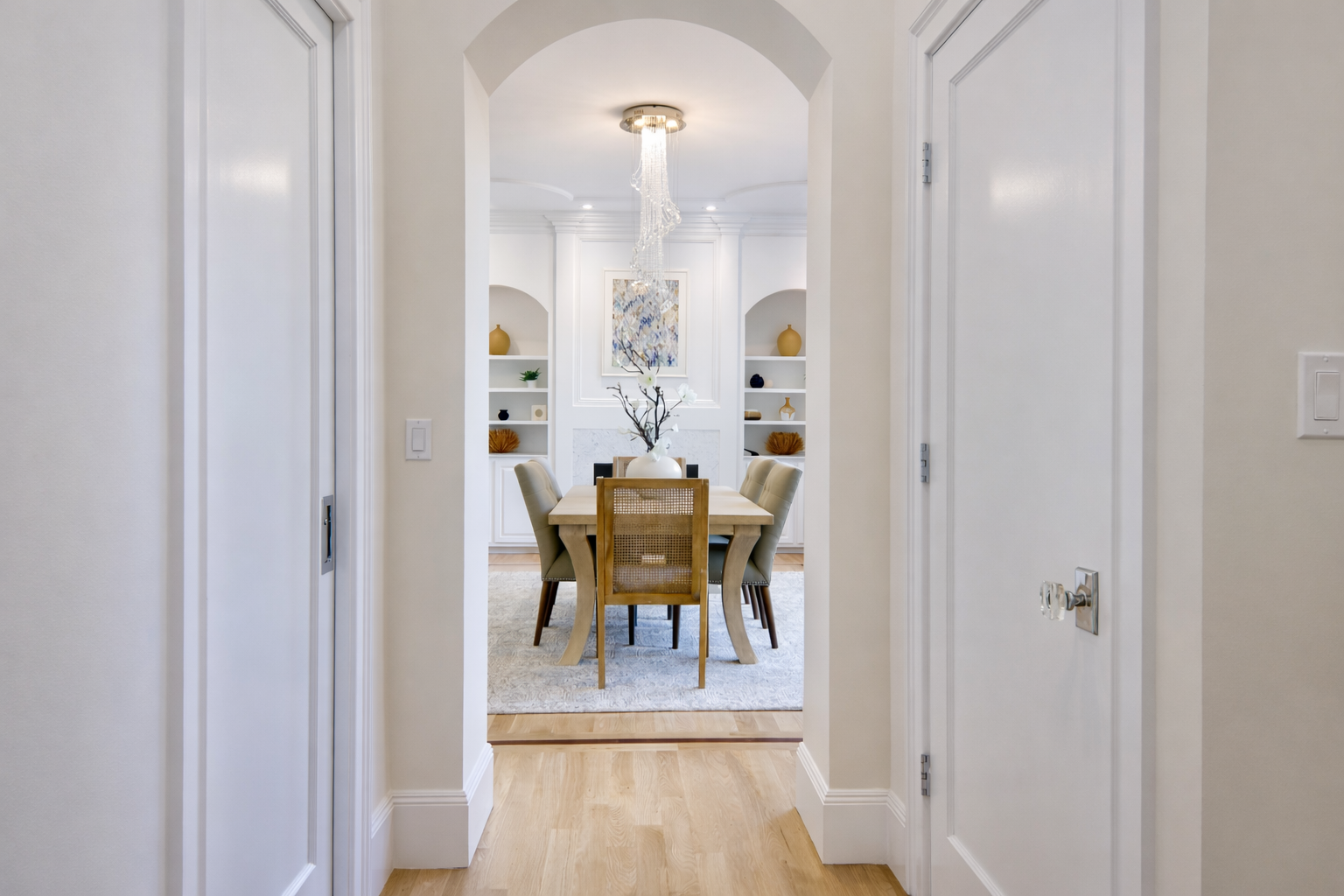 A dining room with a table and chairs and a chandelier
