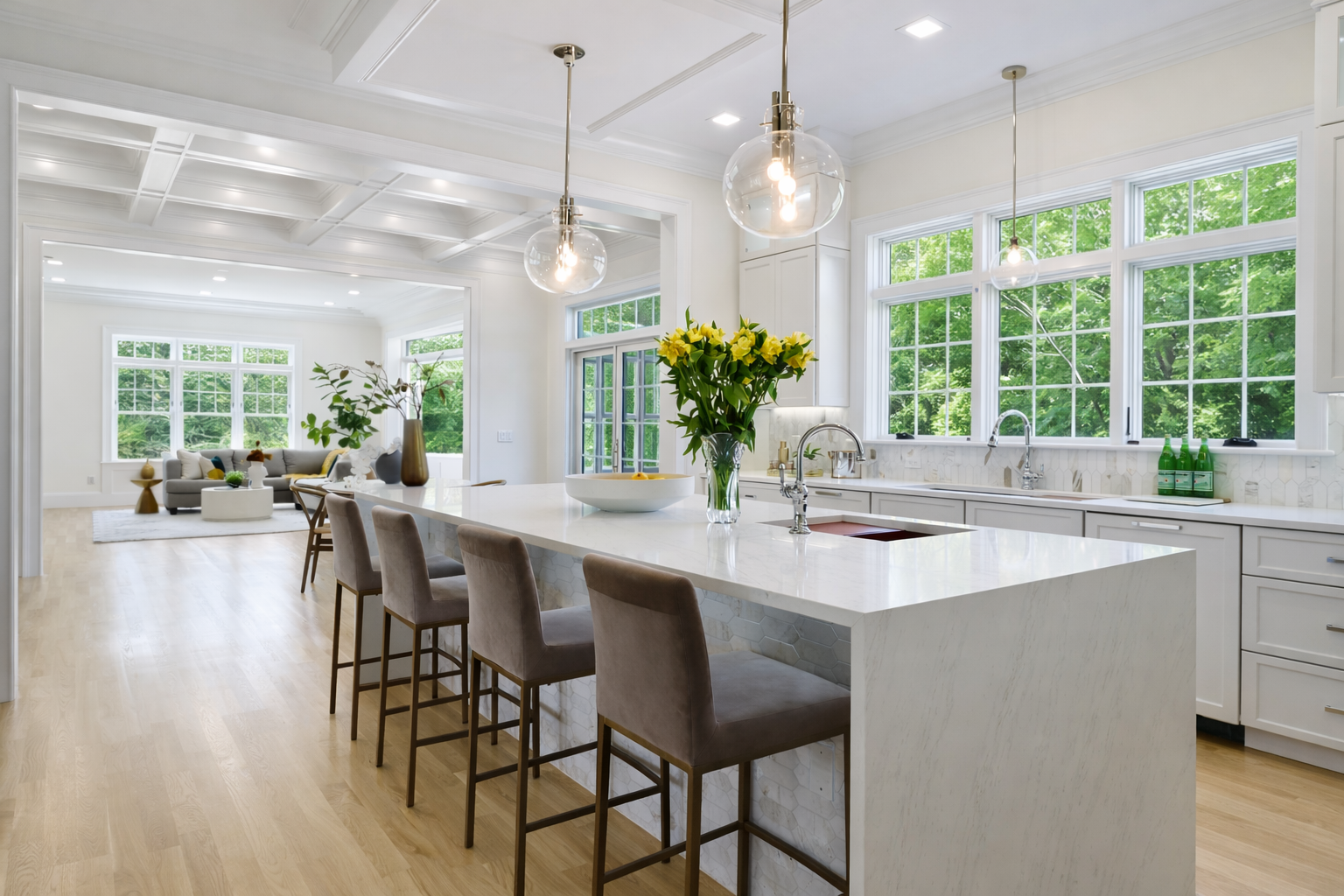 A kitchen with white cabinets and a large island in the middle.
