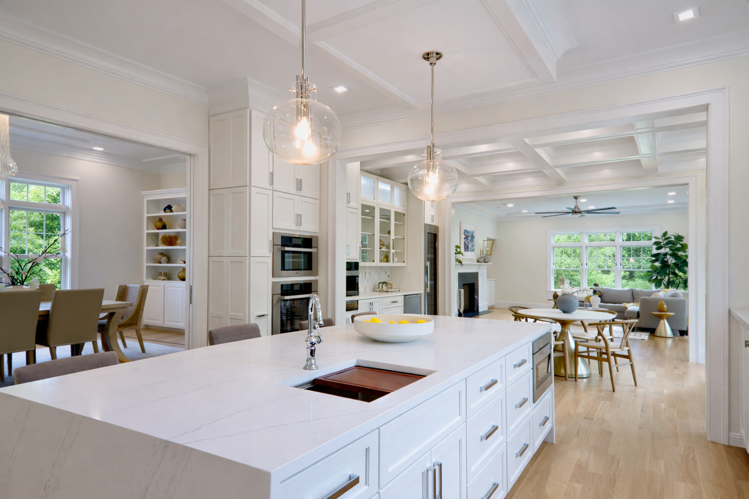 A kitchen with white cabinets and a large island in the middle.