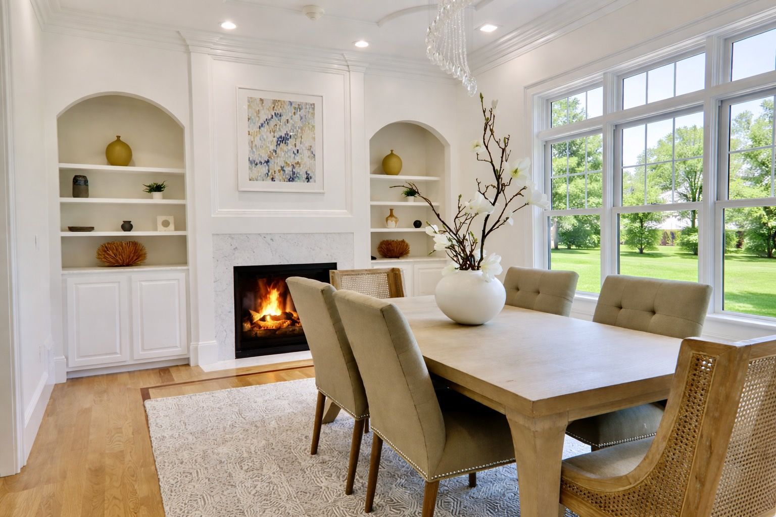 A dining room with a table and chairs and a rug.